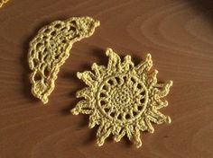 two crocheted doily sitting on top of a wooden table