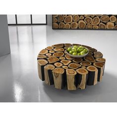 a bowl of fruit on top of a table made out of wood slices and logs