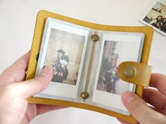 a person holding an open book with pictures on it and a coin in the middle