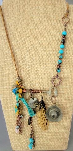 "This is for sure a One Of A Kind necklace. Designed with a genuine skeleton key. Included is vintage Sari silk, ant. copper chain with charms and feathers. A vintage (over 50 years old) cowboy hat (likely made of pewter) that started it's life as a button cover. The necklace has genuine blue semi precious stones (Wagnerite chips and 8mm  reconst. Siderolite with  with copper. Necklace can adjust from a choker length to a  a Princess length, depending on body type. I can easily fit it over my head and adjust from there. Micro-suede gives this a more casual appeal.  The \"Story\" charm represents what everyone has...a story. The vintage pieces add to that. Perhaps the hat and feathers speak to a person who was raised on a farm or horse farm or their family comes from a farm background. It c Bohemian Charm Necklaces For Vintage Collection, Bohemian Bronze Jewelry With Vintage Charm, Bronze Bohemian Jewelry With Vintage Charm, Bohemian Bronze Jewelry For Vintage Collection, Bohemian Style Bronze Jewelry For Vintage Collection, Bohemian Bronze Necklaces With Charms, Bohemian Bronze Necklace With Charms, Bronze Bohemian Necklace With Charms, Bohemian Jewelry With Keys As Gift