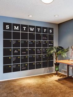 a room with a desk and a large calendar on the wall