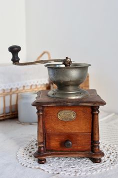 an old fashioned coffee grinder sitting on top of a table