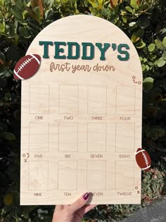 a wooden calendar with footballs on it and the words teddy's first year down