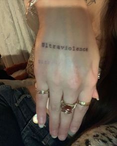 a woman's left hand with the words, literature written on it and two gold rings