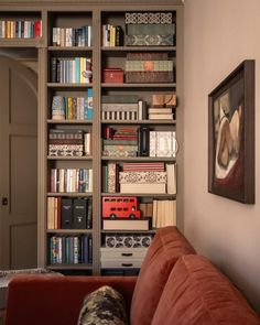 a couch sitting in front of a book shelf filled with books