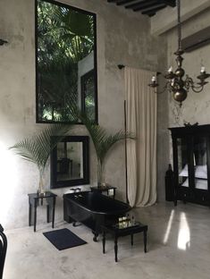 a living room filled with furniture and a chandelier hanging from the ceiling next to a window