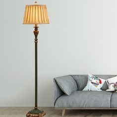 a living room with a couch and lamp on the floor