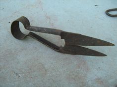 an old pair of scissors sitting on the ground