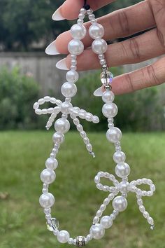 a hand holding a necklace made out of pearls