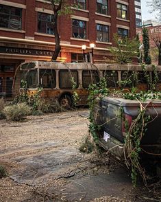 an old bus parked in front of a building with ivy growing on it's roof