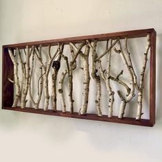 a wooden frame with branches hanging on the wall