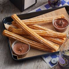 some churro sticks are on a tray with dipping sauces