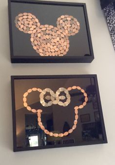 two framed mickey mouse heads are hanging on the wall in front of a mirror with beads