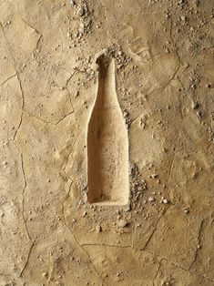 an empty bottle sitting in the middle of dirt