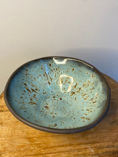 a blue bowl sitting on top of a wooden table