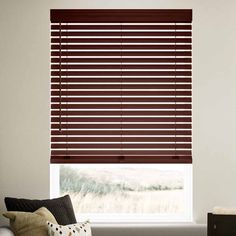 a living room with a couch and window covered in blinds