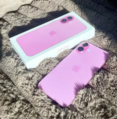 two pink iphone cases sitting on top of a furry surface