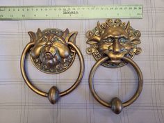 two brass lion head door knockers are on display