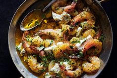 a pan filled with shrimp and vegetables on top of a table