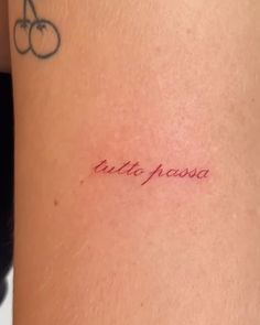 a small tattoo on the back of a woman's left arm that reads, little pissa