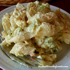 a white plate topped with macaroni salad and a fork