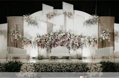 a wedding stage decorated with flowers and greenery