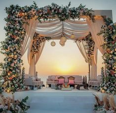 an outdoor wedding set up with white and pink flowers on the stage, overlooking the ocean