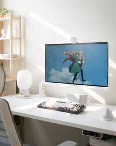 a flat screen tv sitting on top of a white desk next to a keyboard and mouse