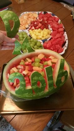 a watermelon carved to look like the word love is displayed on a table