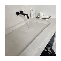 a white sink with black faucet and soap dispenser next to it