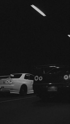 two cars parked next to each other in the dark