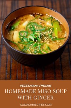 a bowl of vegetable miso soup with ginger and sesame seeds in it on a wooden table