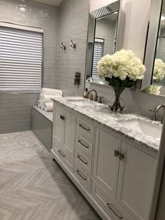 a large bathroom with two sinks and mirrors