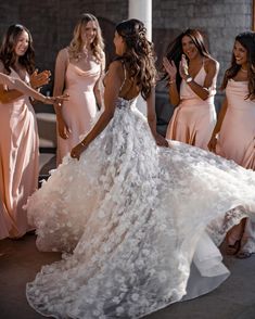 a group of women standing next to each other in long dresses and one woman wearing a dress