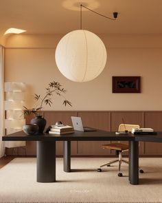 a table with a laptop on top of it in front of a lamp hanging from the ceiling