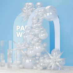 an arch with balloons and snowflakes on it in front of a blue background