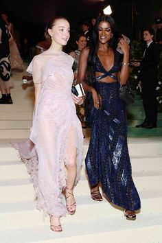 two women in evening dresses walking down stairs