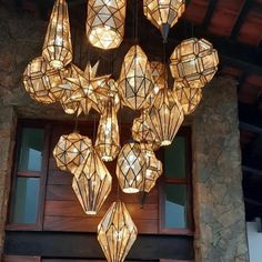 a chandelier hanging from the ceiling in front of a building with many lights on it