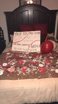 a bed topped with lots of red and white confetti next to a sign