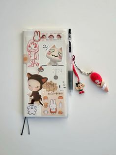 a notebook with various stickers on it and a keychain attached to the cover