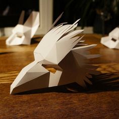 three paper birds sitting on top of a wooden table