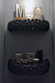 two black shelves in the corner of a room with items on top and below them