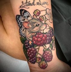 a tattoo with a mouse and berries on it's arm that says stand still