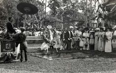 an old black and white photo of people standing around