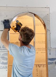 a man in blue shirt using a power drill to cut up the wall with a circular saw