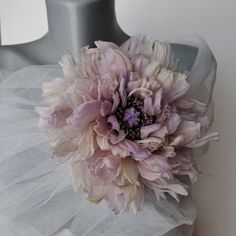 a large pink flower sitting on top of a mannequin