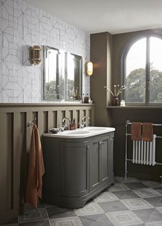 a bathroom with two sinks, a radiator and a towel rack on the wall