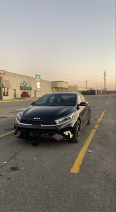 a car parked in a parking lot next to a gas station with no one around it