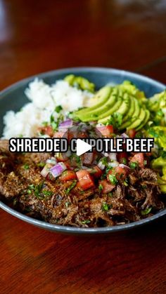 shredded pulled pork with avocado and salsa in a bowl on a wooden table