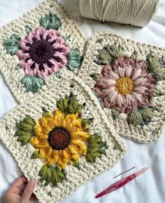 three crocheted coasters with sunflowers on them and yarn next to it